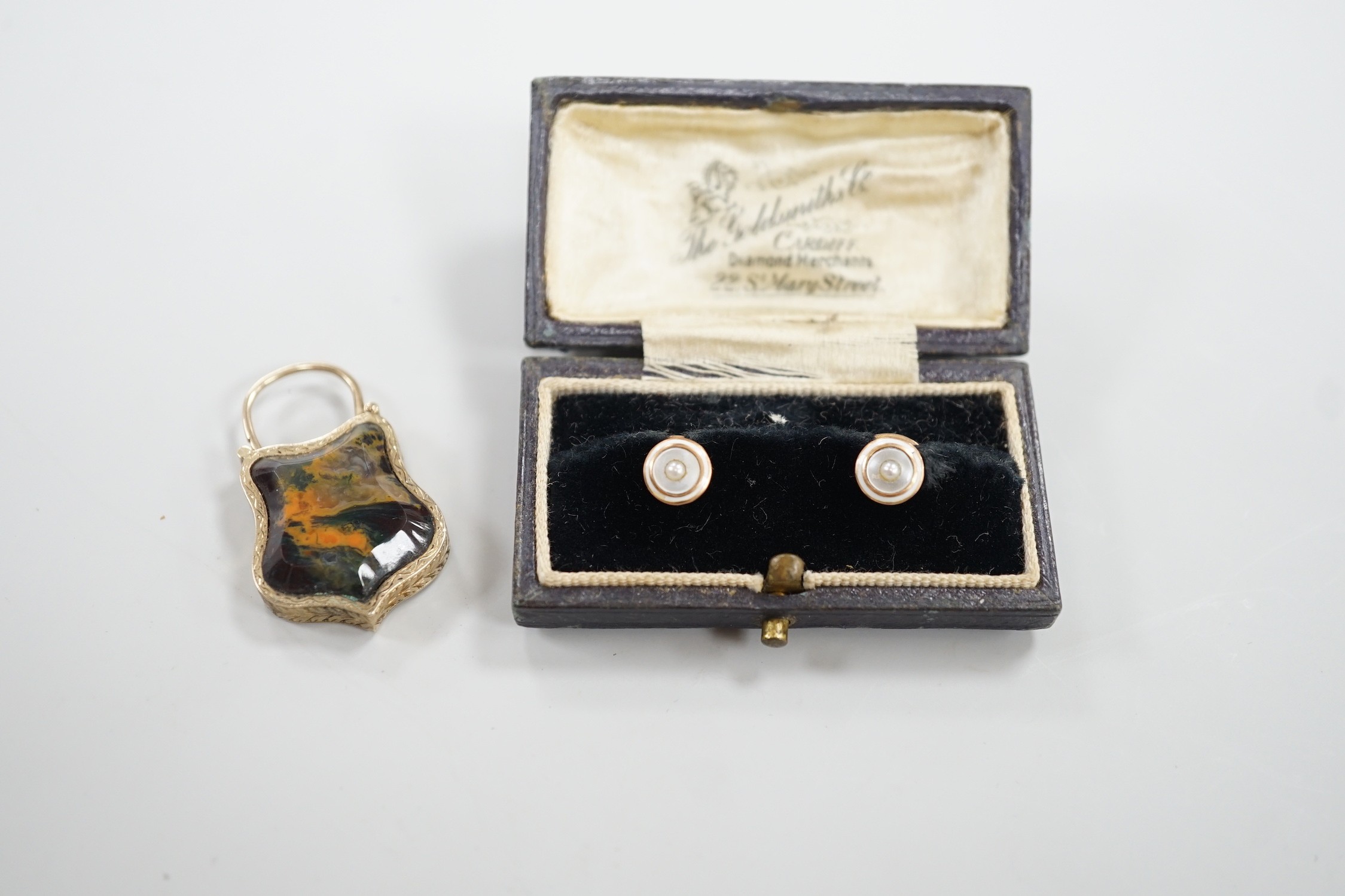 A late Victorian yellow metal and Scottish hardstone set padlock charm, with glazed panel verso, 34mm and a pair of 9ct and mother of pearl studs.